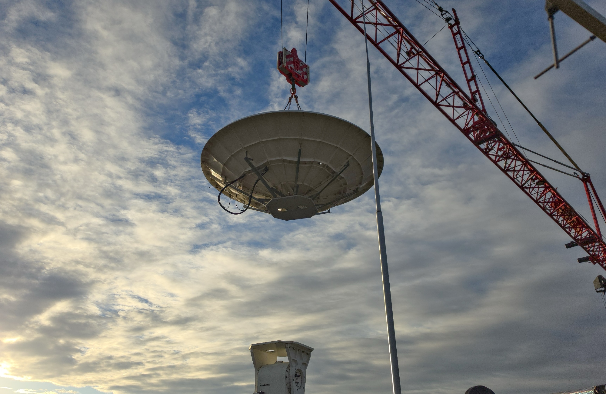 Removing the dish from the old positioner with a crane